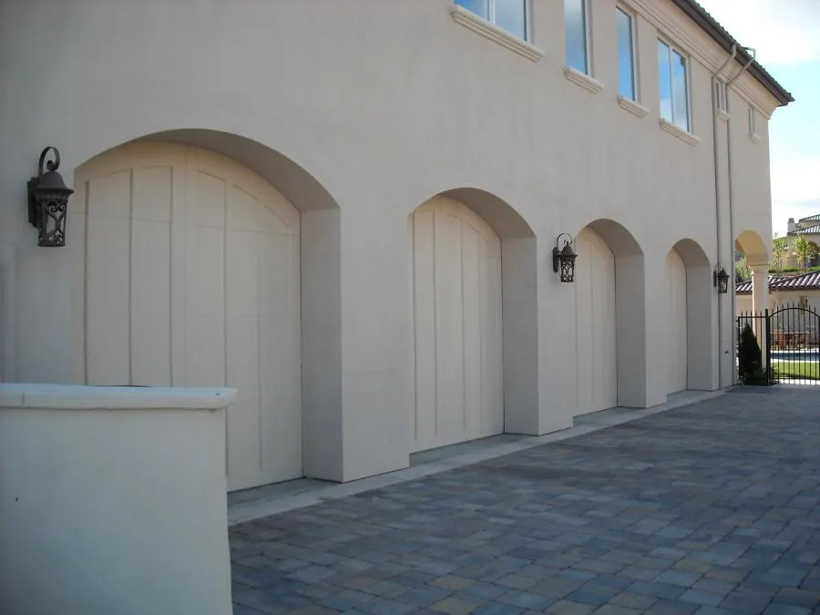  Exterior view of a building with multiple arched doors and outdoor lanterns, set on a paved driveway.