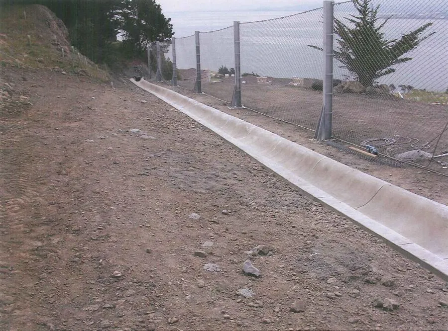Picture of A newly installed drainage channel by Engineered Soil Repairs, Inc. runs alongside a secure fence, exemplifying the company's focus on quality outcomes in erosion control. Copyright ©2025 Diamond Certified Resource. - Engineered Soil Repairs, Inc.