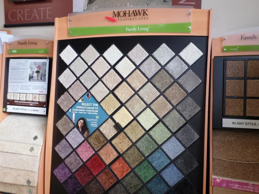 Picture of In a quiet corner of The Floor Store, a vibrant display of carpet swatches invites customers to select their perfect match, reflecting the store's focus on quality outcomes. Copyright ©2025 Diamond Certified Resource - The Floor Store