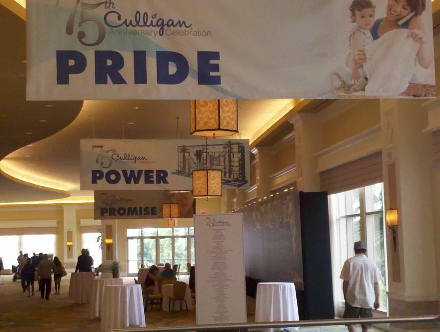 Picture of At Culligan Water of Sonoma County's 75th Anniversary Celebration, banners displaying "Pride," "Power," and "Promise" adorn the venue. This moment highlights the company's focus on quality outcomes, emphasizing its top-rated performance for quality. Copyright ©2025 Diamond Certified Resource - Culligan Water of Sonoma County