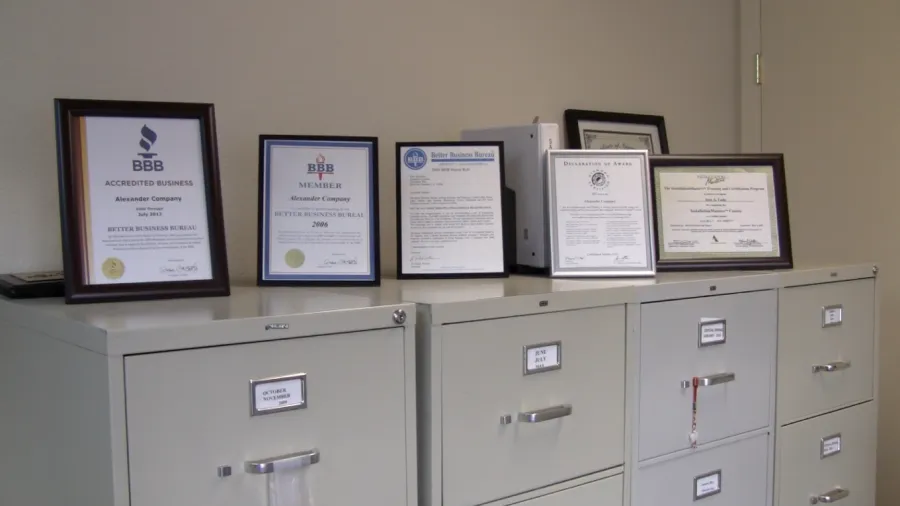 Picture of Along a row of filing cabinets, certificates and accolades proudly display Alexander Company's consistent achievement of the Highest in Quality rating. This commitment to excellence is a testament to their focus on quality outcomes and customer satisfaction. Copyright ©2025 Diamond Certified Resource - Alexander Company
