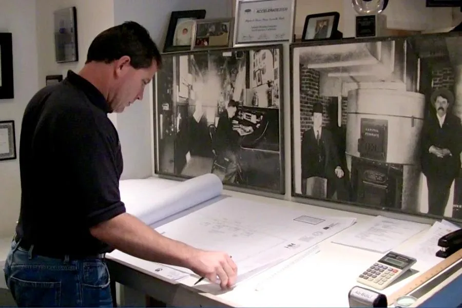 Picture of In a quiet corner filled with history, a Schmitt Heating Company, Inc. professional reviews detailed blueprints, embodying the firm’s commitment to quality outcomes. Recognized for expertise and quality, the company continues to build on its legacy. Copyright ©2025 Diamond Certified Resource. - Schmitt Heating Company, Inc.