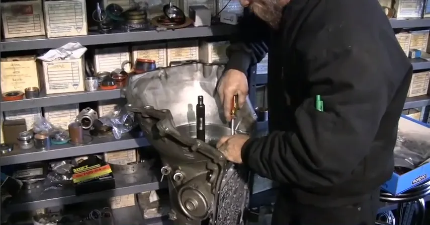 Picture of In a workshop filled with neatly organized parts, a technician skillfully works on a transmission, reflecting Delta Transmission's focus on quality outcomes. Their commitment to craftsmanship consistently earns them high customer satisfaction ratings. Copyright ©2025 Diamond Certified Resource

 - Delta Transmission