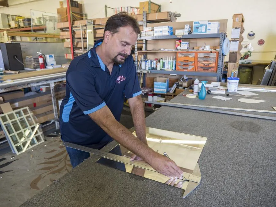 Picture of  In the workshop of Able Glass Company, precision meets expertise as a craftsman carefully measures a piece of glass, embodying the firm's dedication to quality. Recognized for its expertise and quality, the company ensures each project reflects these values. Copyright ©2025 Diamond Certified Resource.

 - Able Glass Company