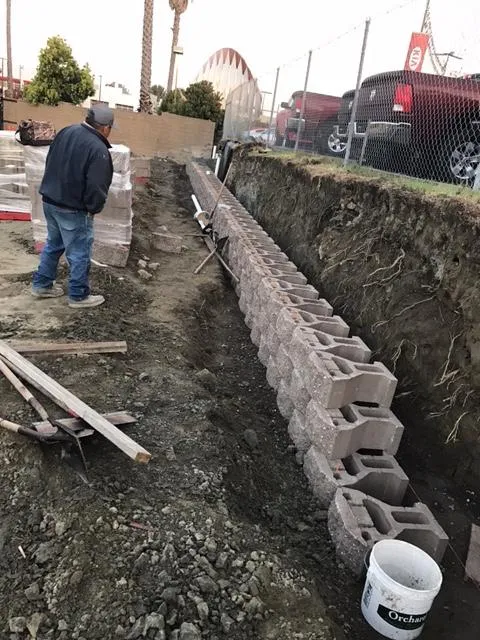Picture of  A worker assesses the alignment of freshly laid concrete blocks, showcasing Bay Area Drainage, Inc.'s commitment to quality outcomes. The project reflects the company's dedication to high customer satisfaction and expert craftsmanship. Copyright ©2025 Diamond Certified Resource.

 - Bay Area Drainage, Inc.