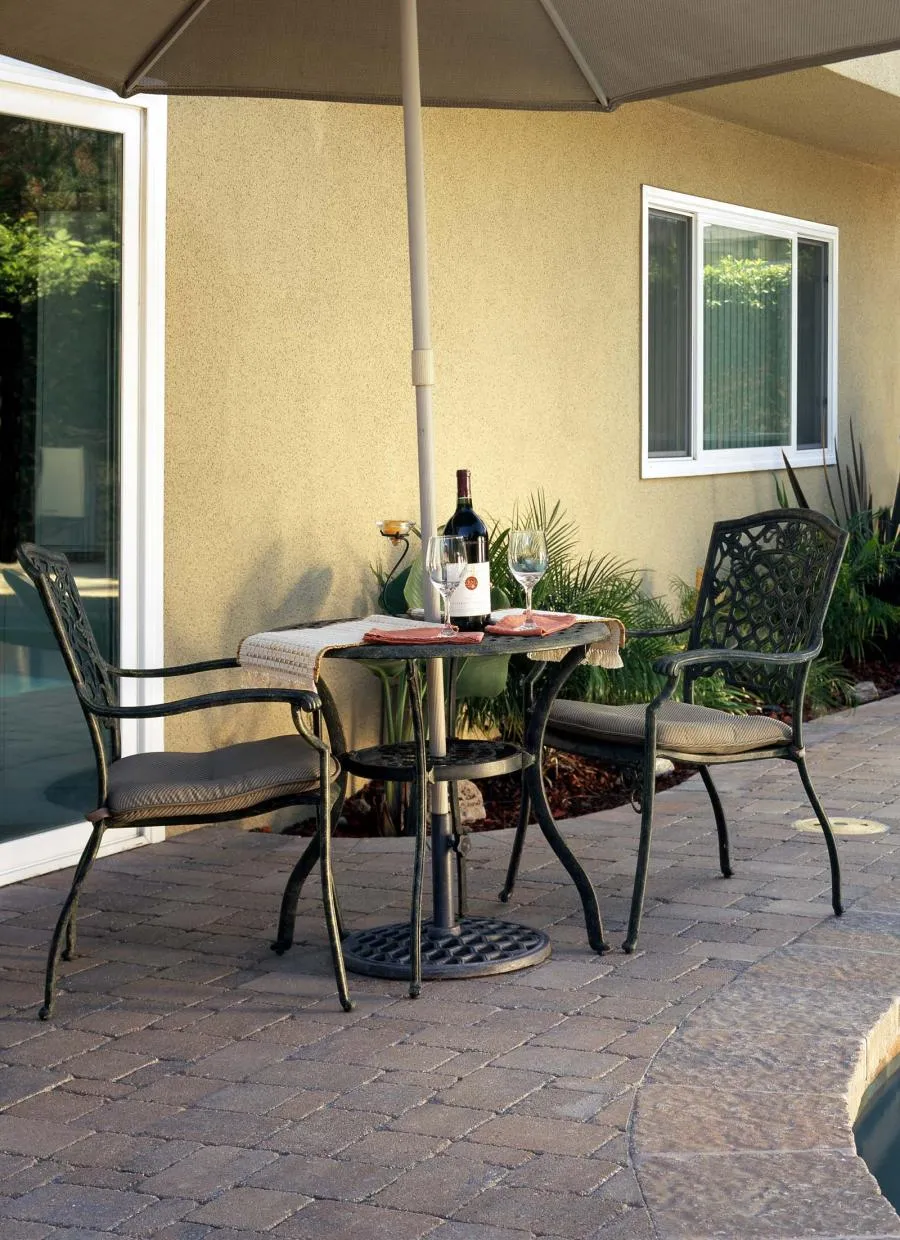 Picture of  Under the serene shade of an umbrella, a table set for two invites quiet conversation by the poolside, a testament to Black Diamond Paver Stones & Landscape, Inc.'s focus on quality outcomes. Copyright ©2025 Diamond Certified Resource.

 - Black Diamond Paver Stones & Landscape, Inc.