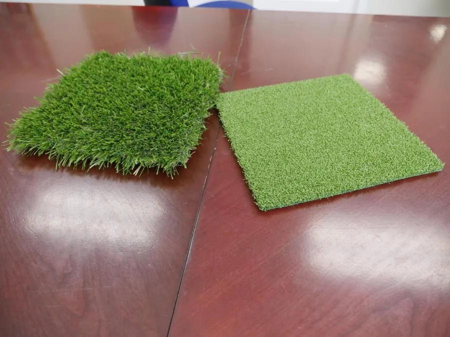 Picture of  Two samples of artificial grass lie on a polished wooden table, capturing Black Diamond Paver Stones & Landscape, Inc.'s commitment to quality outcomes in every project. As a top-rated company for Quality, they demonstrate their expertise in design choices. Copyright ©2025 Diamond Certified Resource.

 - Black Diamond Paver Stones & Landscape, Inc.