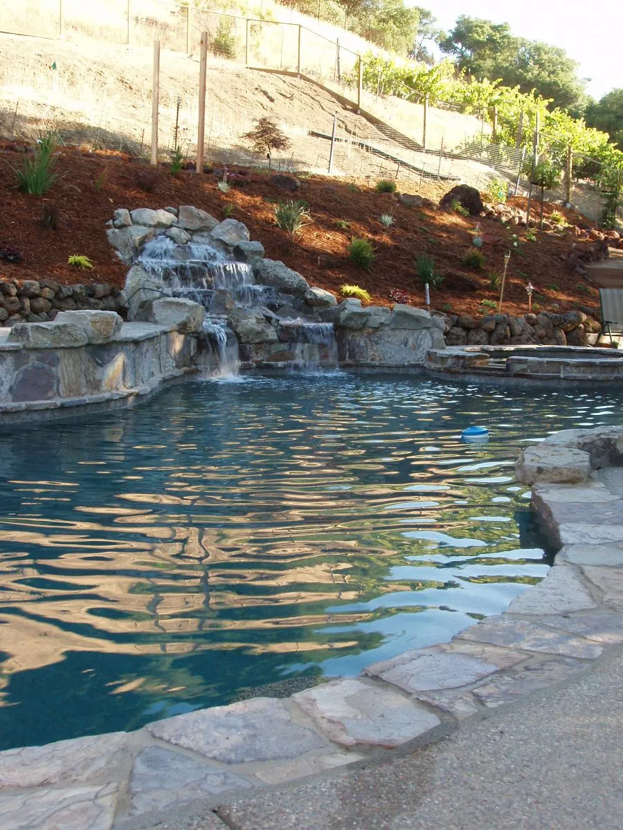 Picture of In this serene backyard sanctuary, Classic Pools integrates natural rock formations with gentle waterfalls, creating a tranquil escape that highlights their top-rated quality. Copyright ©2025 Diamond Certified Resource - Classic Pools