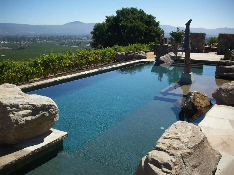 Picture of Amidst a serene landscape, a meticulously crafted pool by Classic Pools reflects the commitment to quality outcomes, offering a tranquil escape. The natural stone and clear water seamlessly blend with the surroundings. Copyright ©2025 Diamond Certified Resource

 - Classic Pools