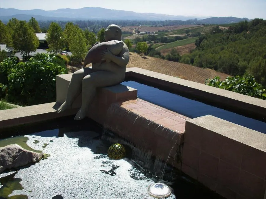 Picture of A tranquil statue holding a fish overlooks an elegant landscape, perfectly integrated into a cascading water feature crafted by Classic Pools, recognized for expertise and quality. Copyright ©2025 Diamond Certified Resource

 - Classic Pools