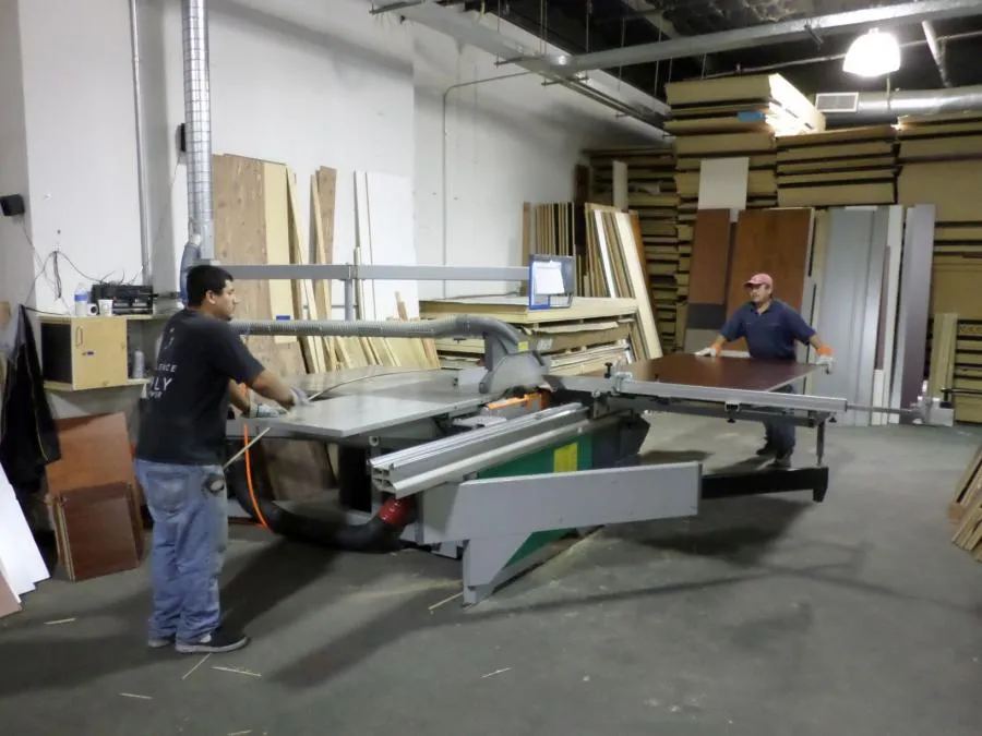 Picture of In the heart of the workshop, two skilled craftsmen operate precision machinery, transforming raw materials into custom designs for Closet Factory. The company's focus on quality outcomes remains evident in every meticulous cut. Copyright ©2025 Diamond Certified Resource

 - Closet Factory