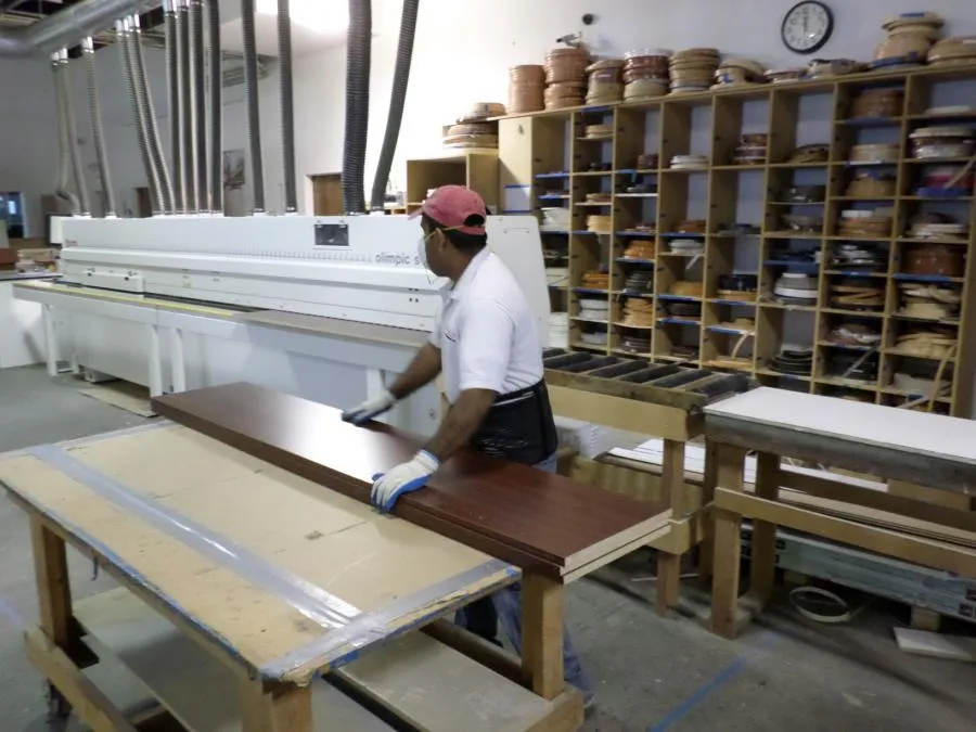 Picture of In a neatly organized workshop, a craftsman at Closet Factory carefully works on a wooden panel, showcasing the company's focus on quality outcomes. This image reflects their commitment to craftsmanship. Copyright ©2025 Diamond Certified Resource

 - Closet Factory