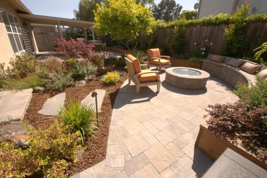 Picture of A tranquil garden patio with cushioned seating encircles a modern fire pit, an inviting space crafted with precision. Black Diamond Paver Stones & Landscape, Inc. focuses on quality outcomes. Copyright ©2025 Diamond Certified Resource. - Black Diamond Paver Stones & Landscape, Inc.