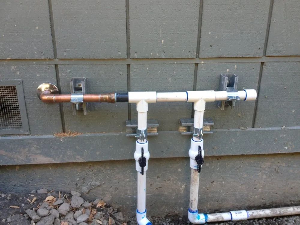 Picture of A precise network of PVC and copper piping is expertly installed against a weathered wall, showcasing Elite Plumbing Services' commitment to quality outcomes. Their focus on excellence has consistently earned them a Highest in Quality rating. Copyright ©2025 Diamond Certified Resource - Elite Plumbing Services