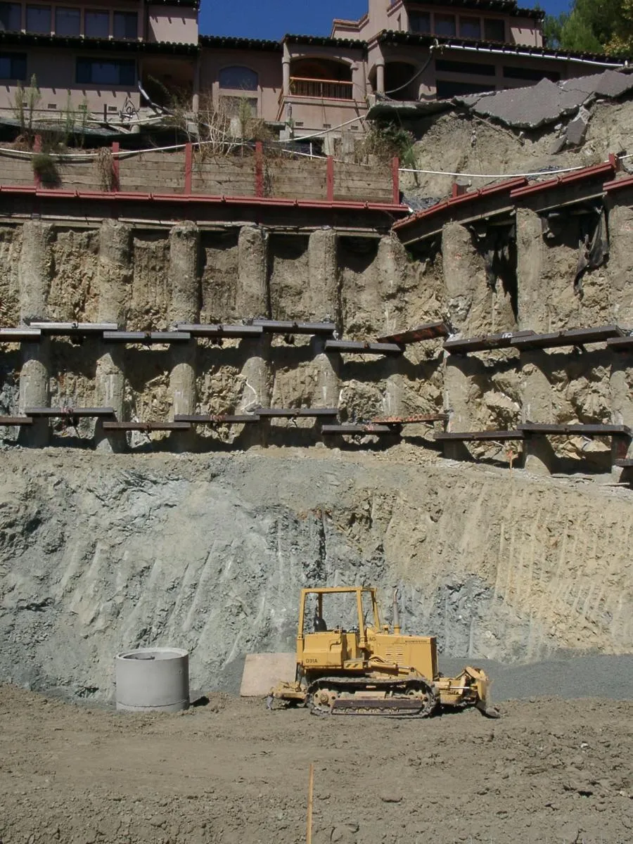 Picture of A bulldozer rests at the foot of a meticulously reinforced hillside, a testament to Engineered Soil Repairs, Inc.'s commitment to quality outcomes. Their expertise in soil stabilization ensures the safety of hillside structures. Copyright ©2025 Diamond Certified Resource. - Engineered Soil Repairs, Inc.