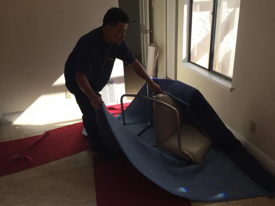 Picture of  In a sunlit room, a professional from Advantage Moving & Storage carefully wraps a chair in a protective blanket, ensuring its safe transport. This meticulous attention to detail exemplifies why the company consistently achieves a Highest in Quality rating. Copyright ©2025 Diamond Certified Resource.

 - Advantage Moving & Storage