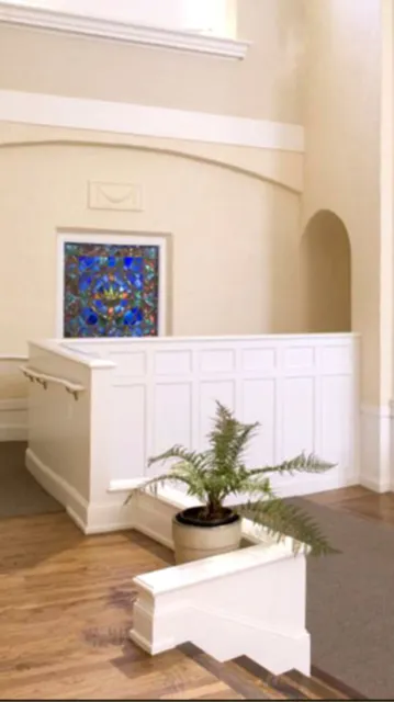  Interior space with white wainscoting, stained glass window, wooden flooring, and a potted fern.