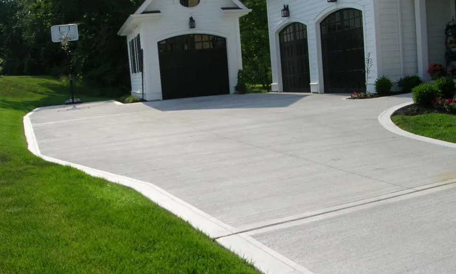 Picture of A newly paved driveway leads to elegant garage doors, framed by lush greenery, showcasing Kodiak Construction's focus on quality outcomes. Copyright ©2025 Diamond Certified Resource

 - Kodiak Construction