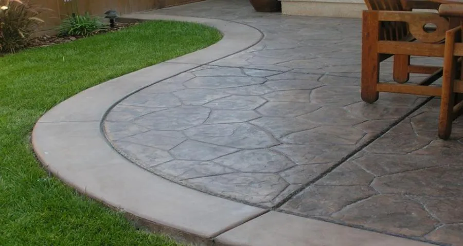 Picture of A meticulously crafted curved patio seamlessly blends with lush green grass, showcasing Kodiak Construction's focus on quality outcomes. Their dedication is evident in the fine detailing of this outdoor space. Copyright ©2025 Diamond Certified Resource - Kodiak Construction
