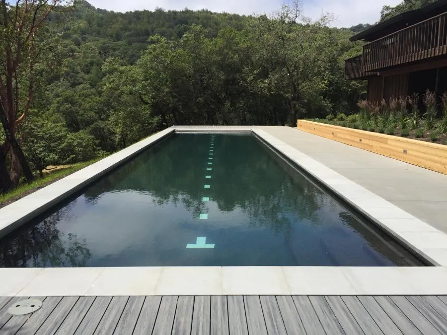 Picture of Nestled amidst lush greenery, a sleek rectangular pool reflects the serene surroundings, exemplifying Classic Pools' focus on quality outcomes. The tranquil setting invites relaxation and connection with nature. Copyright ©2025 Diamond Certified Resource - Classic Pools
