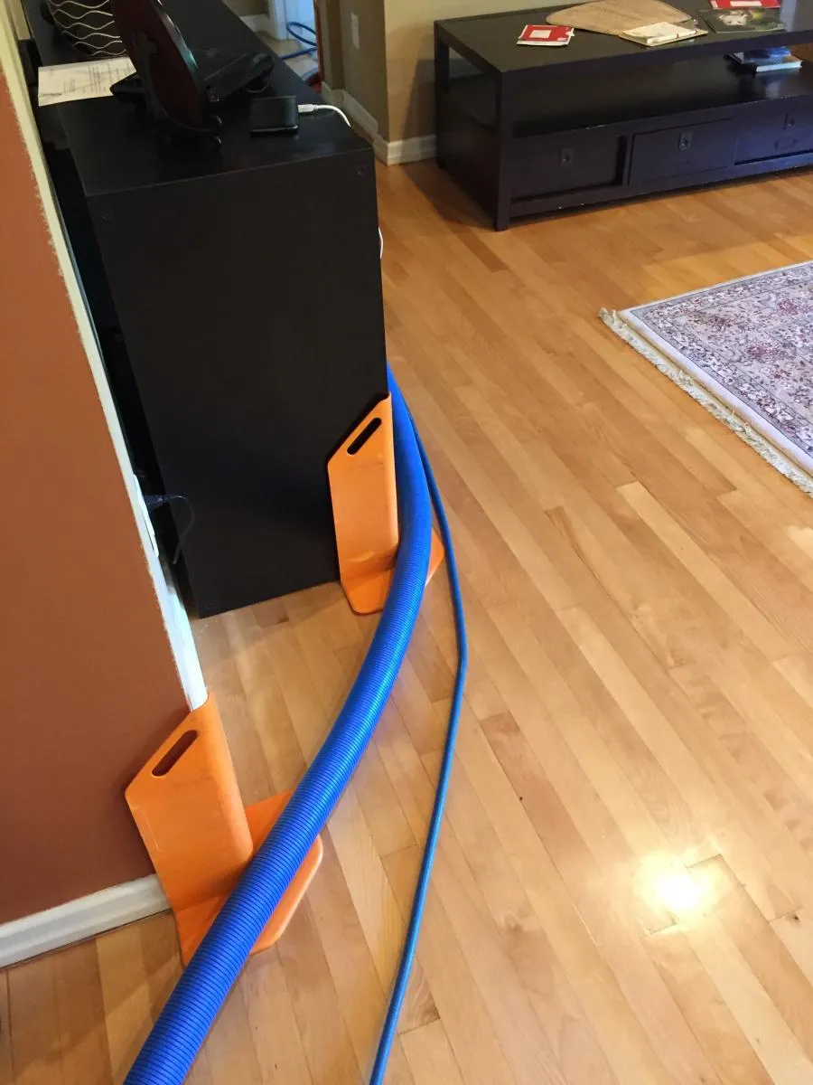 Picture of In a quiet corner of a room, Maximum Carpet Cleaning's equipment stands ready, a testament to their focus on quality outcomes. The orange protectors and blue hoses suggest meticulous care. Copyright ©2025 Diamond Certified Resource

 - Maximum Carpet Cleaning