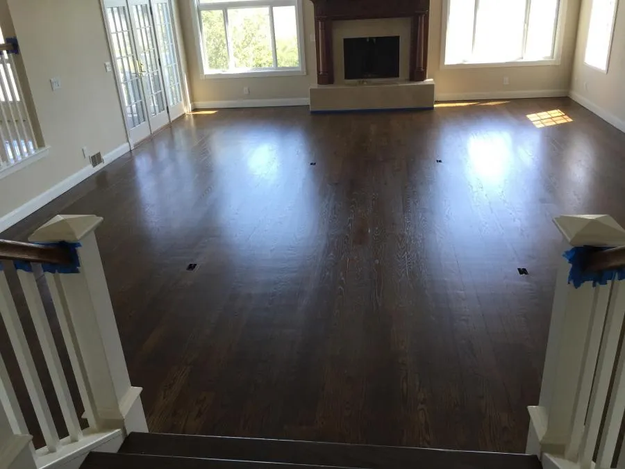 Picture of Sunlight streams through large windows, illuminating the newly finished hardwood floors in a spacious living room, a testament to NBE Property Restorationâ€™s focus on quality outcomes. Copyright ©2025 Diamond Certified Resource - NBE Property Restoration