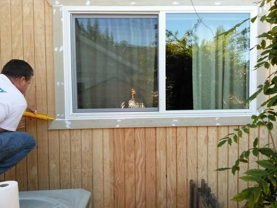 Picture of A worker meticulously applies caulk around a newly installed window, ensuring a flawless finish. NBE Property Restorationâ€™s commitment to quality outcomes shines through in every detail. Copyright ©2025 Diamond Certified Resource

 - NBE Property Restoration
