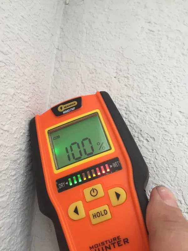 Picture of A moisture meter reveals a concerning 100% reading on a textured wall surface, indicating a potential issue that NBE Property Restoration is equipped to address with their expertise. Recognized for their expertise and quality, they can restore integrity with precision. Copyright ©2025 Diamond Certified Resource

 - NBE Property Restoration
