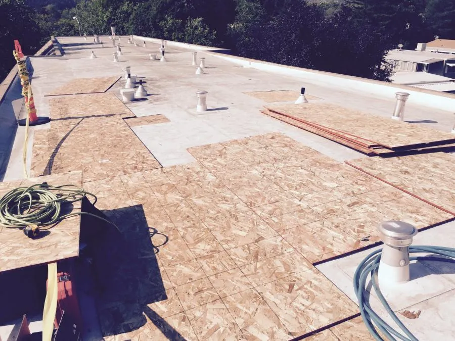 Picture of Amidst a rooftop transformation, NBE Property Restoration meticulously places plywood sheets, ensuring precise alignment. This attention to detail highlights their focus on quality outcomes and consistently achieving a Highest in Quality rating. Copyright ©2025 Diamond Certified Resource

 - NBE Property Restoration