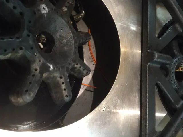  Close-up of a clean stovetop burner, showing intricate metal components and surrounding surfaces.