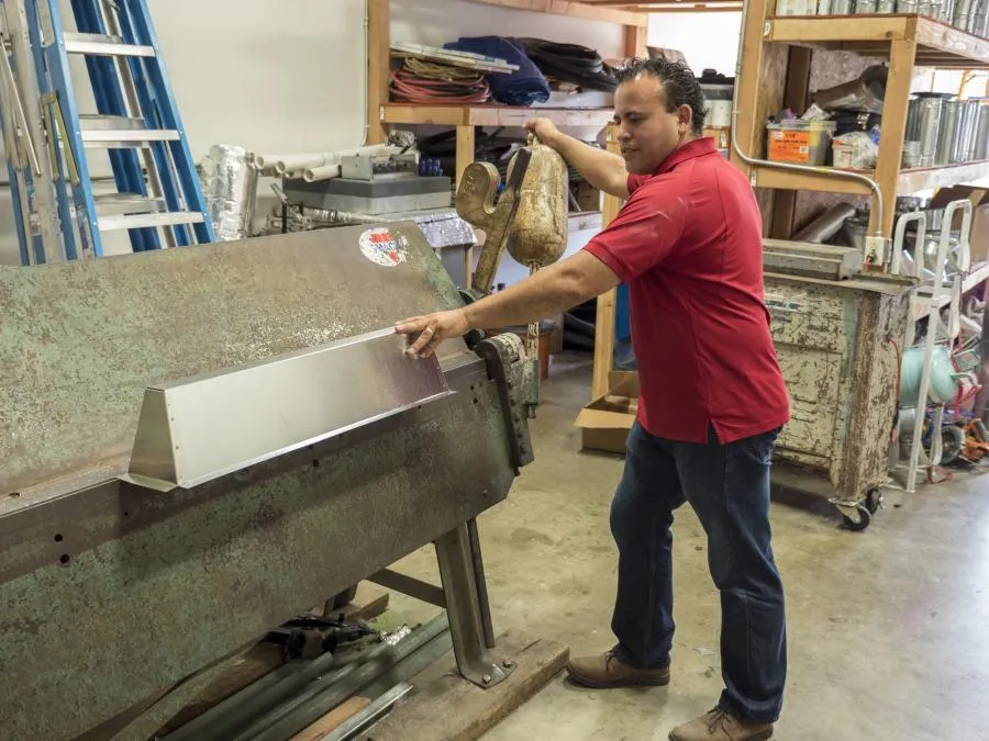 Picture of In a workshop bustling with tools and materials, an Ortiz Heating and Air Conditioning technician skillfully operates a sheet metal brake, showcasing the companyâ€™s focus on quality outcomes. Relied upon for consistently achieving the highest in quality ratings, Ortiz continues to impress with its craftsmanship. Copyright ©2025 Diamond Certified Resource

 - Ortiz Heating and Air Conditioning