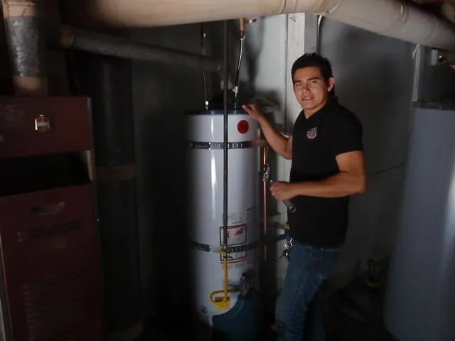 Picture of In the dimly lit room, a technician from Atlas Plumbing & Rooter inspects a water heater, embodying the companyâ€™s focus on quality outcomes. Copyright ©2025 Diamond Certified Resource

 - Atlas Plumbing & Rooter