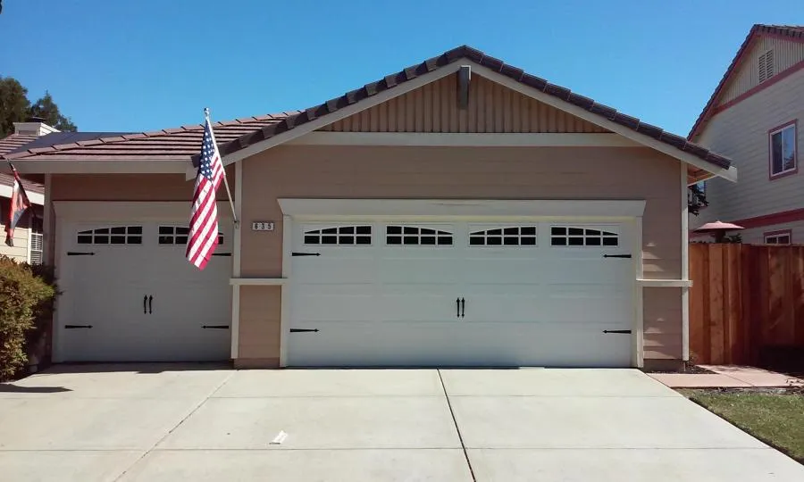 Picture of The pristine garage doors by R & P Garage Doors stand as a testament to their top-rated quality. An American flag waves gently, reflecting the company's commitment to excellence. Copyright ©2025 Diamond Certified Resource

 - R & P Garage Doors