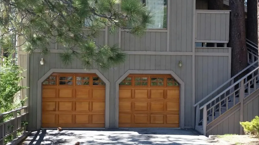 Picture of Nestled under the shade of lush pine trees, this home features beautifully crafted wooden garage doors by R & P Garage Doors. Their attention to detail and focus on quality outcomes consistently impress. Copyright ©2025 Diamond Certified Resource

 - R & P Garage Doors