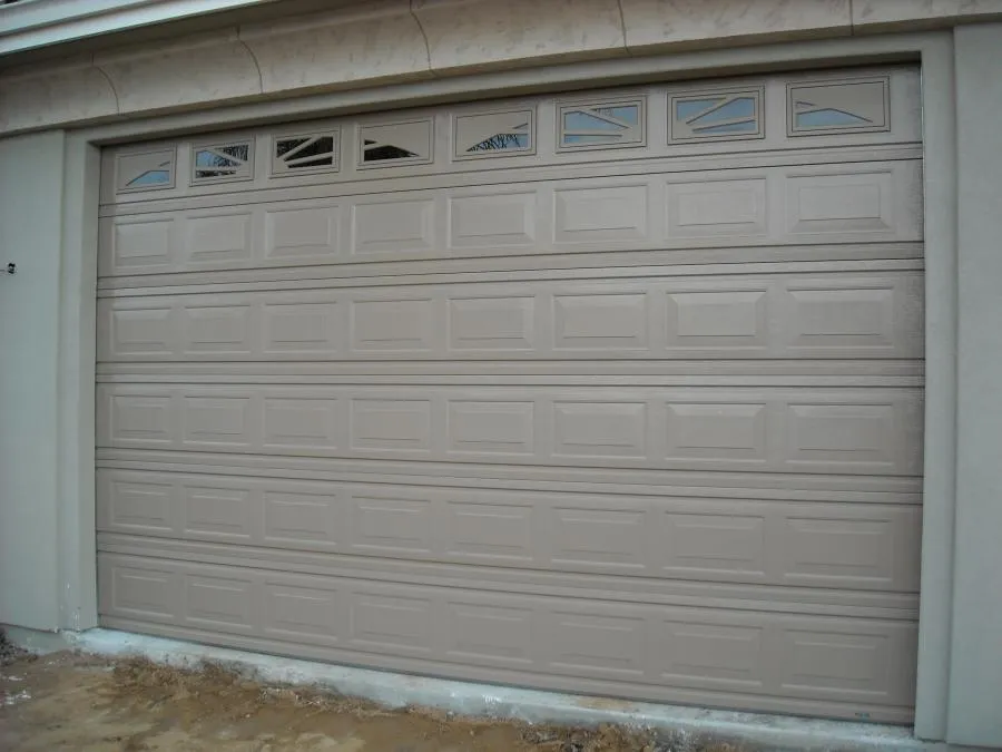 Picture of A newly installed beige garage door, subtly accented with upper panel windows, exemplifies R & P Garage Doors' dedication to quality outcomes. As a company recognized for expertise and quality, their work enhances any home's curb appeal. Copyright ©2025 Diamond Certified Resource

 - R & P Garage Doors