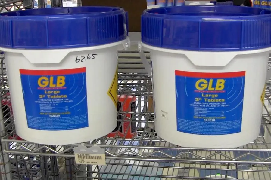 Picture of Two large containers of 3-inch GLB chlorine tablets sit neatly on a metal shelf, ensuring pool water clarity and safety. Roger's Pool & Spa Service Inc. relies on top-quality products like these, contributing to its Highest in Quality rating. Copyright ©2025 Diamond Certified Resource - Roger's Pool & Spa Service Inc.