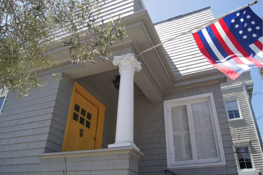 Picture of  A vibrant yellow door stands out against the classic gray siding, highlighting Michael Sack Painting, Inc.'s dedication to quality outcomes in residential transformations. Copyright ©2025 Diamond Certified Resource.

 - Michael Sack Painting, Inc.