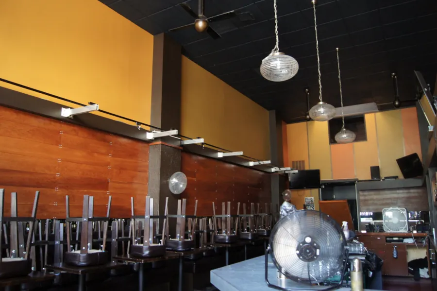 Picture of Amidst an empty room with chairs stacked on tables, a sense of quiet readiness permeates the scene, hinting at a fresh coat soon to be applied by Michael Sack Painting, Inc., a company recognized for expertise and quality. Copyright ©2025 Diamond Certified Resource. - Michael Sack Painting, Inc.