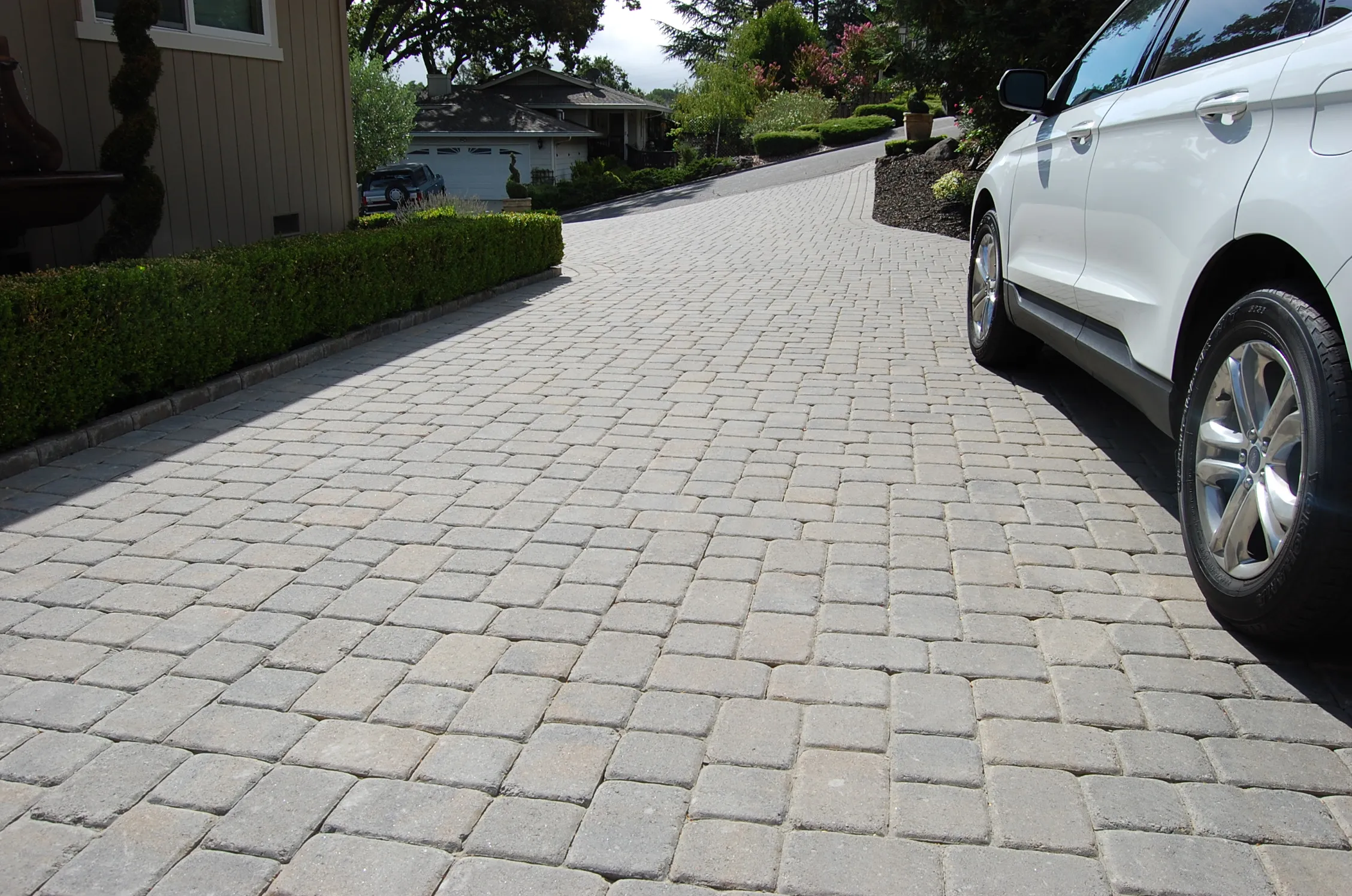 Picture of A meticulously crafted paver driveway winds through a serene neighborhood, exemplifying The Legacy Paver Group's commitment to quality outcomes. Recognized for expertise and quality, the company transforms outdoor spaces into lasting legacies. Copyright ©2025 Diamond Certified Resource

 - The Legacy Paver Group