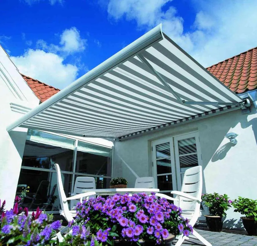 Picture of A sleek, striped awning stretches over a serene patio, offering shade to a tranquil seating area adorned with vibrant purple flowers. Wesco Screen Company Inc., renowned for its quality outcomes, enhances outdoor spaces with precision. Copyright ©2025 Diamond Certified Resource

 - Wesco Screen Company Inc.
