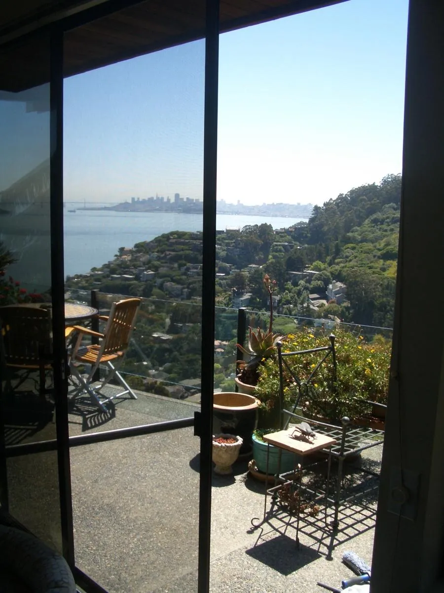 Picture of Through the clear screen installed by Wesco Screen Company Inc., a serene patio setting overlooks the lush hillside and sprawling cityscape beyond, exemplifying their focus on quality outcomes. Copyright ©2025 Diamond Certified Resource

 - Wesco Screen Company Inc.