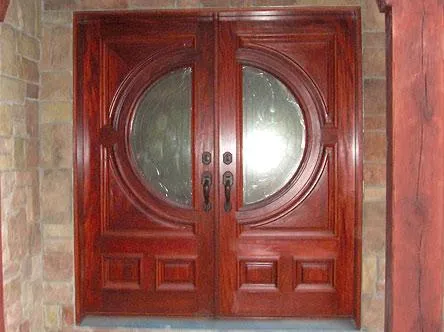 Picture of A pair of intricately designed wooden doors stands as a testament to craftsmanship, reflecting Quality Windows & Doors, Inc.'s focus on quality outcomes. The doors serve as a warm introduction to the elegance within a home. Copyright ©2025 Diamond Certified Resource. - Quality Windows & Doors, Inc.