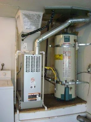  Heating system installation showing furnace and water heater connected with vents and pipes in a utility area.
