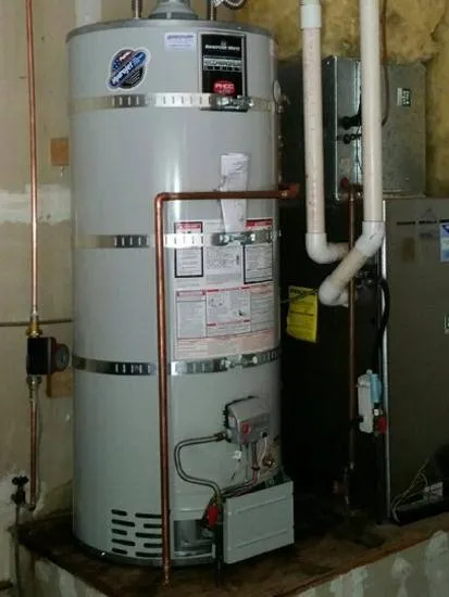 A newly installed water heater in a utility area with surrounding pipes and an adjacent furnace. A newly installed water heater in a utility area with surrounding pipes and an adjacent furnace.