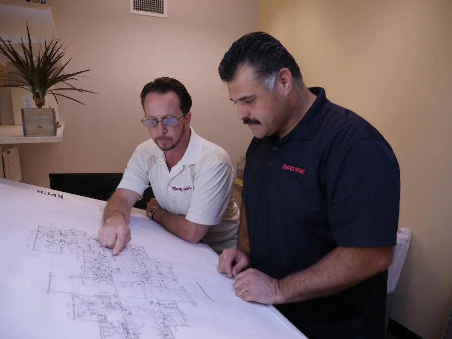 Picture of In the quiet focus of their workspace, two team members of Degree HVAC, Inc. review detailed blueprints, ensuring every aspect meets their high standards. Their commitment to quality outcomes has consistently earned them top ratings. Copyright ©2025 Diamond Certified Resource

 - Degree HVAC, Inc.