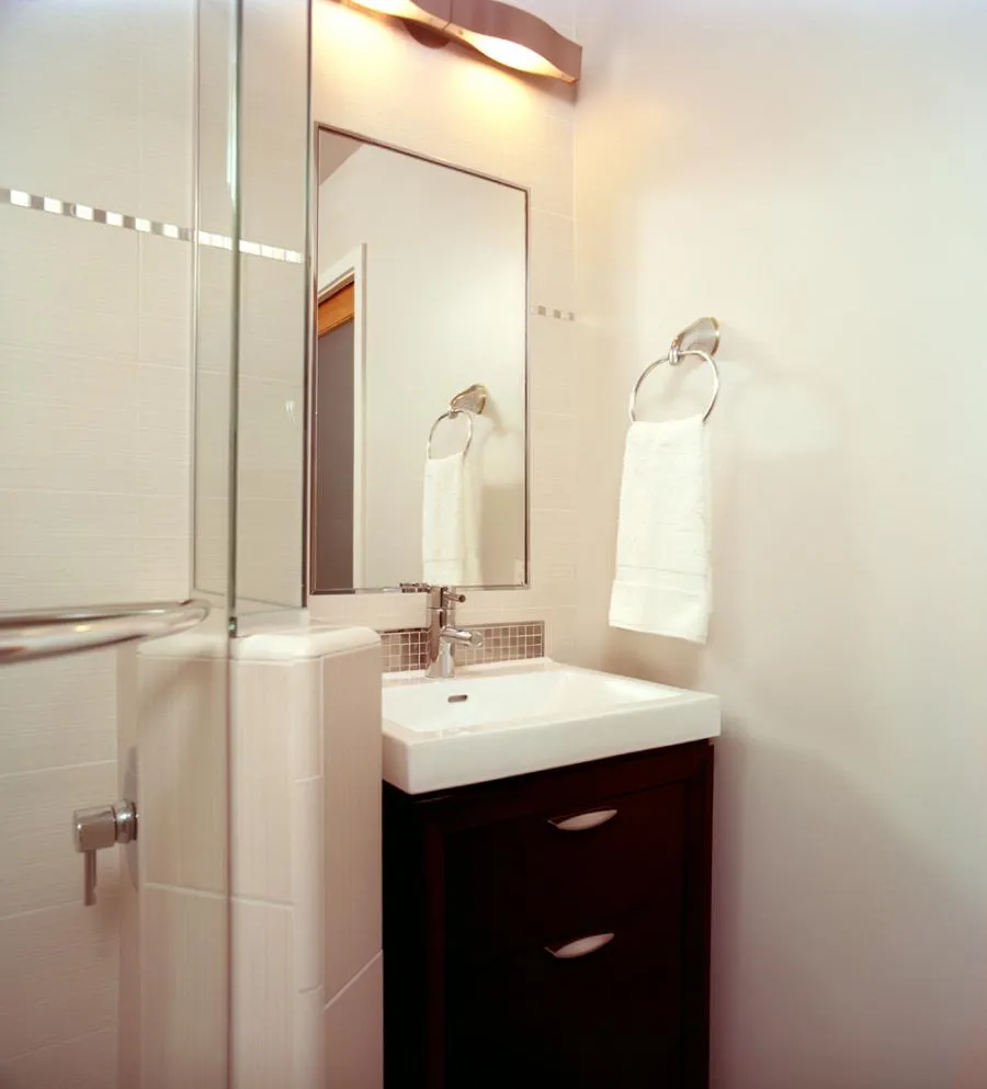 Picture of In this elegantly designed bathroom by Next Stage Design + Build, a sleek white sink and wooden cabinet reflect the company's commitment to quality outcomes. Copyright ©2025 Diamond Certified Resource - Next Stage Design + Build