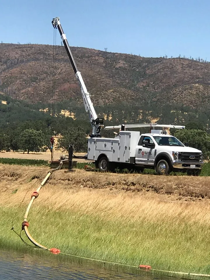 Picture of A McLean & Williams, Inc. service truck equipped with a crane works efficiently beside a rural waterway, showcasing the companyâ€™s top-rated quality and commitment to excellence. Copyright ©2025 Diamond Certified Resource

 - McLean & Williams, Inc.