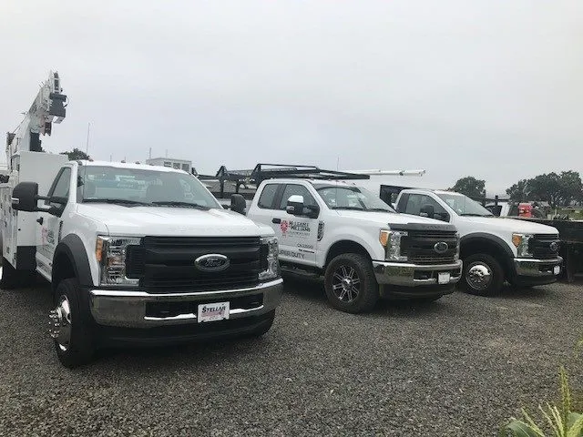 Picture of In a display of readiness, McLean & Williams, Inc.'s fleet stands poised on a gravel lot, a testament to their focus on quality outcomes. Each truck is a crucial part of their top-rated service delivery. Copyright ©2025 Diamond Certified Resource - McLean & Williams, Inc.