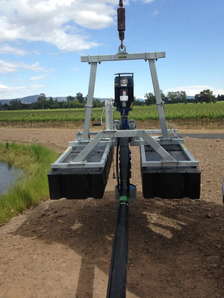 Picture of A robust metal frame, equipped with a motorized mechanism, hovers over a dirt path beside a vineyard. McLean & Williams, Inc.â€™s dedication to quality outcomes is evident in their precision engineering. Copyright ©2025 Diamond Certified Resource - McLean & Williams, Inc.