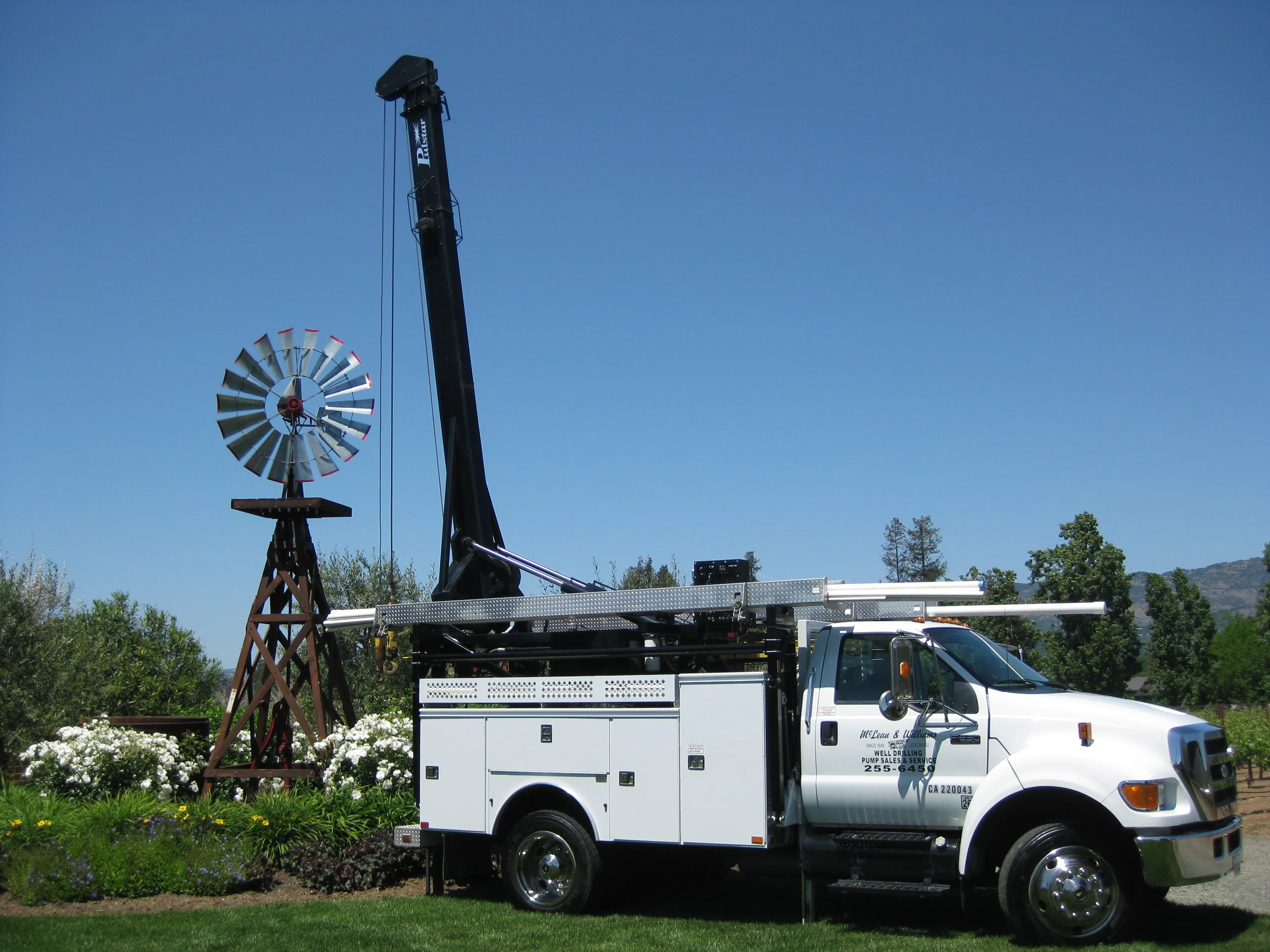 Picture of Amid lush greenery, a McLean & Williams, Inc. service truck stands beside a classic windmill, symbolizing the company's dedication to quality outcomes in their fieldwork. McLean & Williams, Inc. focuses on quality outcomes. Copyright ©2025 Diamond Certified Resource

 - McLean & Williams, Inc.